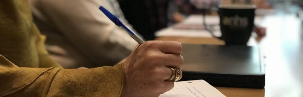 Close up of hand and notepad on a desk