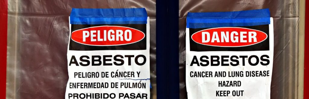 Signs In English And Spanish Warning About Asbestos In School On The Doors